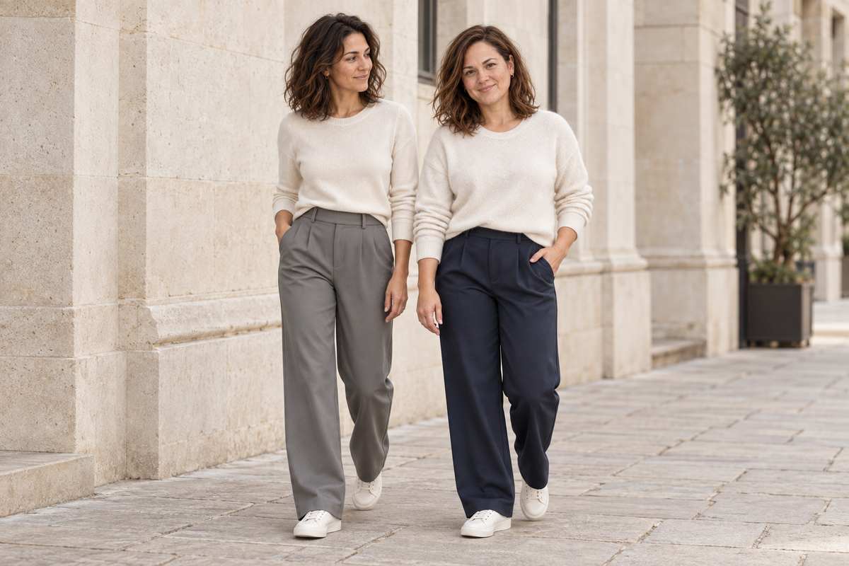 Clara and Elena wearing grey and navy Everyday Trousers with ivory knits on a relaxed day out